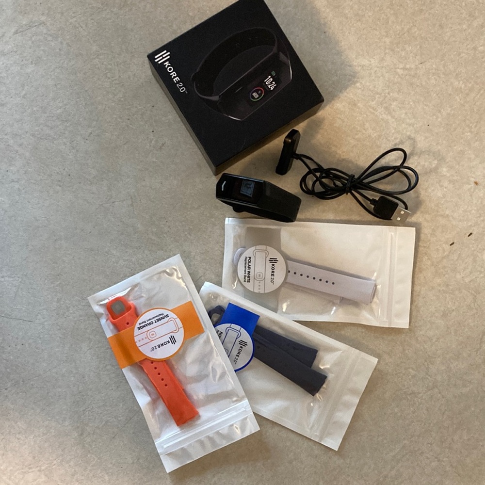 Kore Fitness Tracker.  Tracker, charger, and three extra wrist bands.
